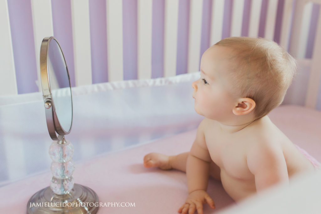 baby looking at herself in mirror