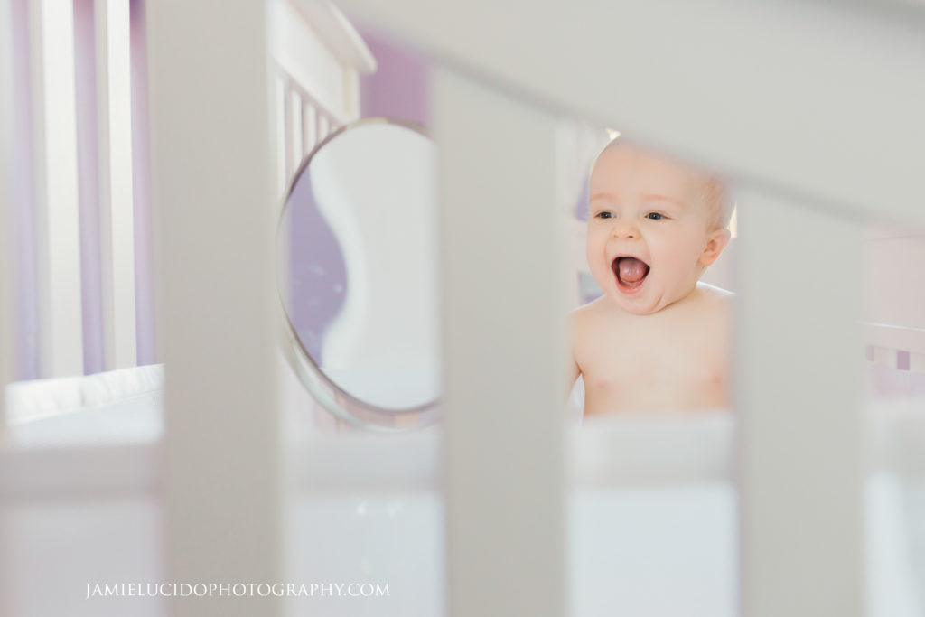 baby in crib laughing lifestyle portrait