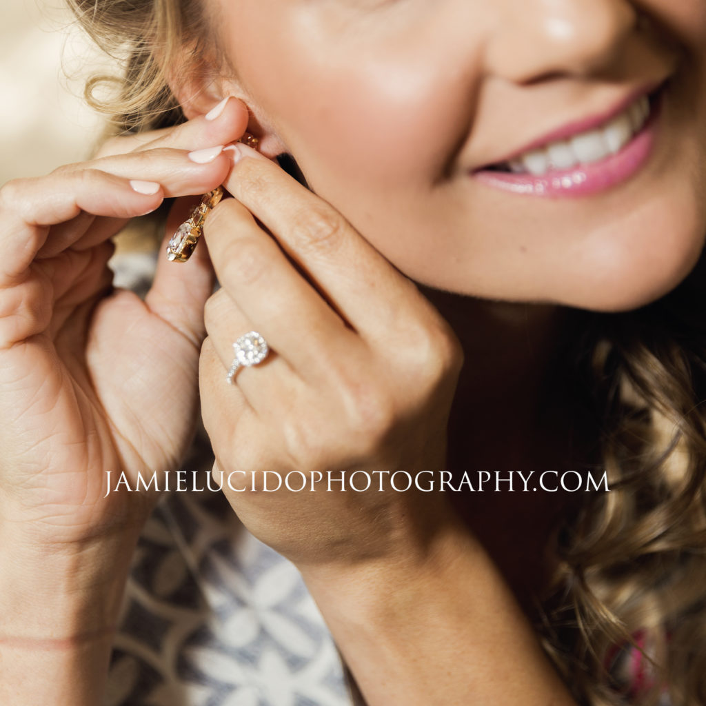 detail of bride putting on earring