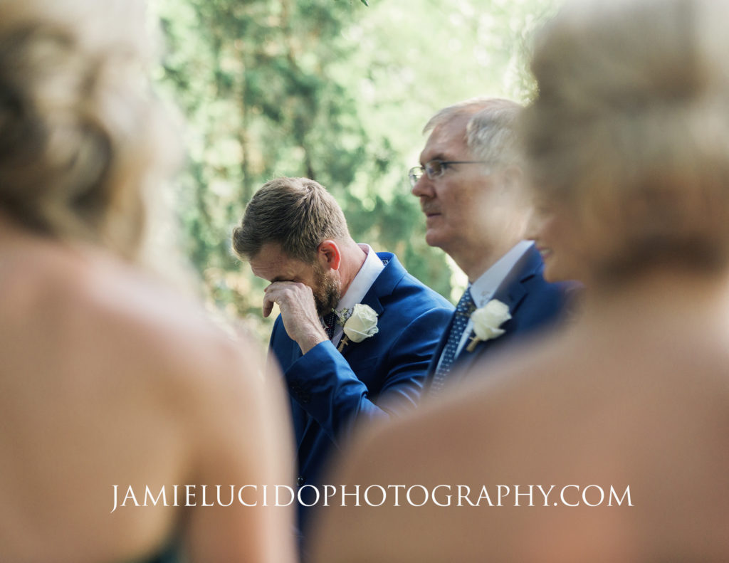 groom wipes tear from his eye during ceremony