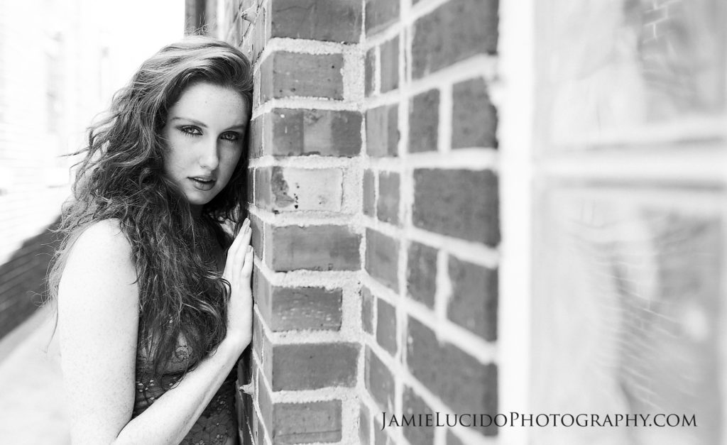 model leaning on brick wall