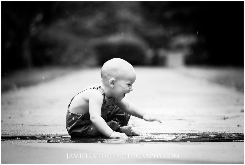 family and children's photography, baby splashing in rain, puddle, documentary, family photography, portrait photography, black and white photography, 10 month old