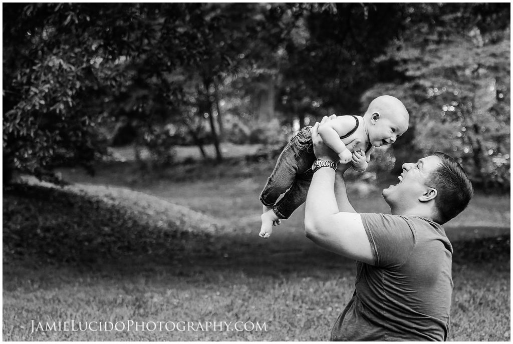 baby in father's arms, father lifting baby, documentary portrait, lifestyle portrait, portrait photography, family photography, milestone photography