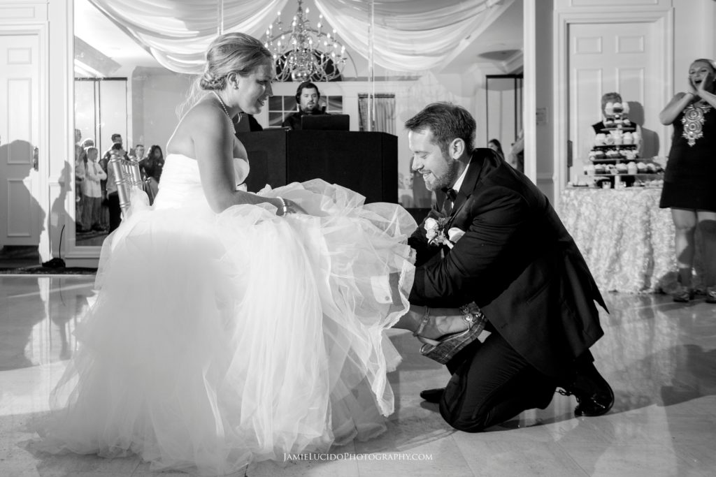 groom gets garter, garter toss, wedding reception photo